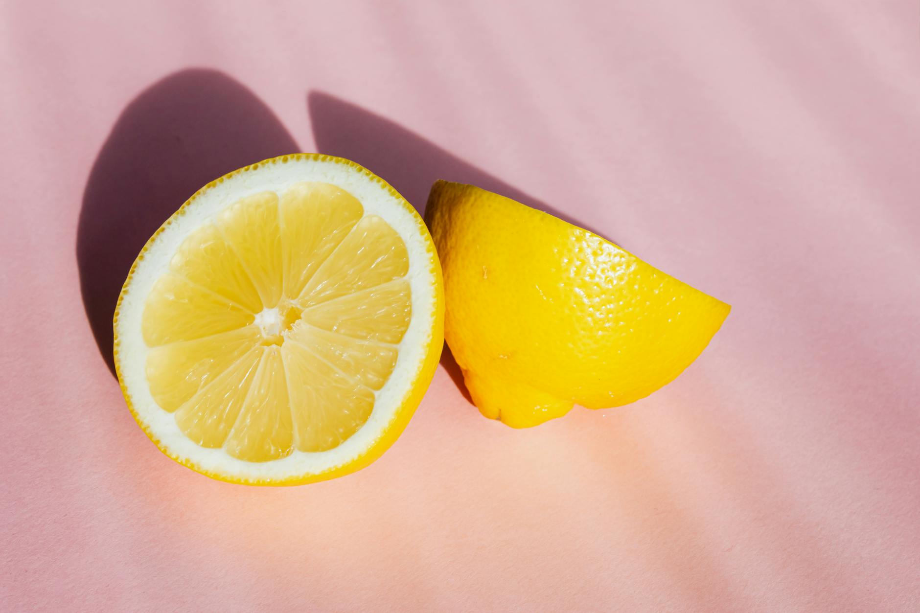 Una mano che tiene un limone fresco su sfondo giallo vivace, che simboleggia il ritorno al piacere consapevole