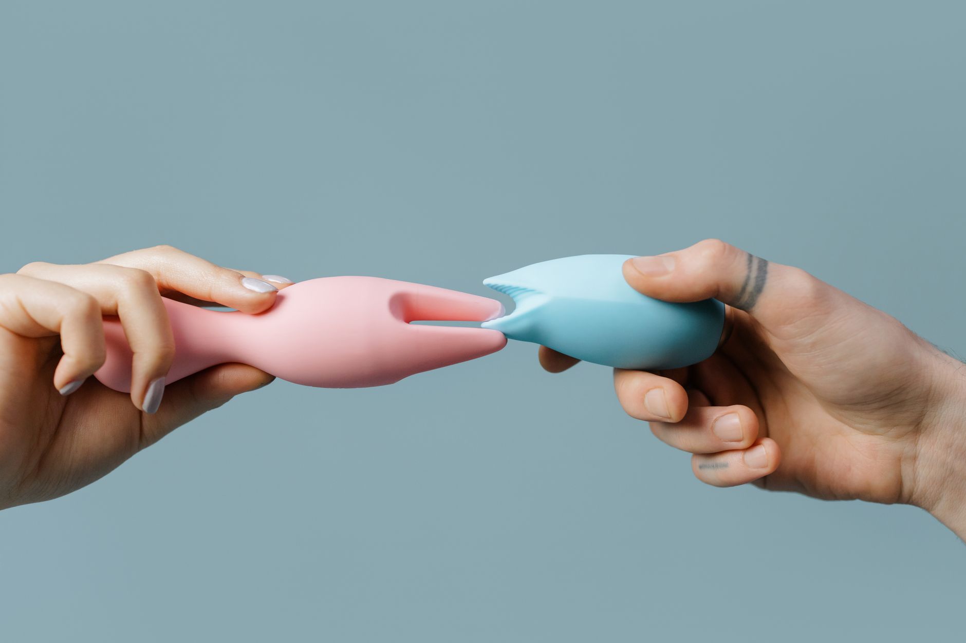 Mani che tengono un vibratore blu elegante su sfondo viola, che simboleggia l'intimità moderna e la scoperta del piacere